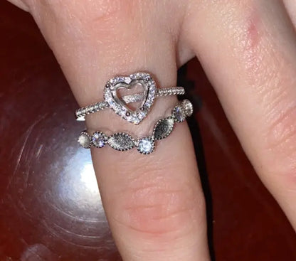 Silver heart-shaped breastmilk keepsake ring displayed on hand next to a second breastmilk ring.