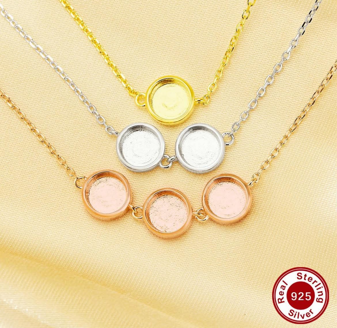 Three round bezel pendant necklaces in yellow gold, white gold, and rose gold, displayed on a textured beige fabric background with a 'Real Sterling Silver 925' badge in the bottom right corner.